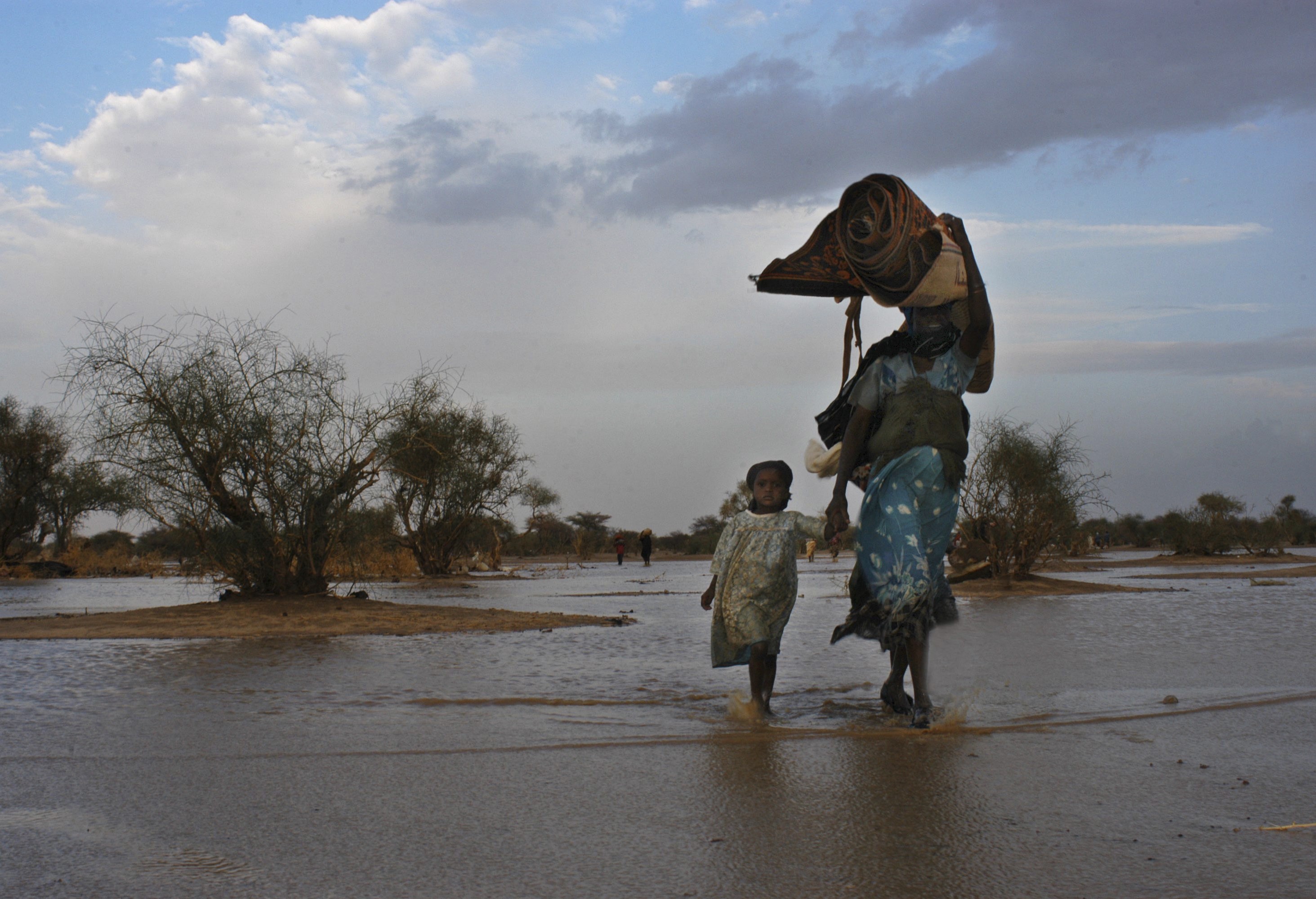 Sudanese refugees from the Darfur region looking for a new shelter in eastern Chad after heavy rains in 2004. (UNHCR/Hélène Caux)